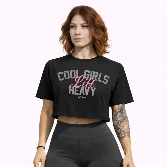 Modelo mujer con crop top Cool Girls Rckiss, vista frontal con tatuajes florales, pantalón deportivo gris, mujer fitness crossfit gym