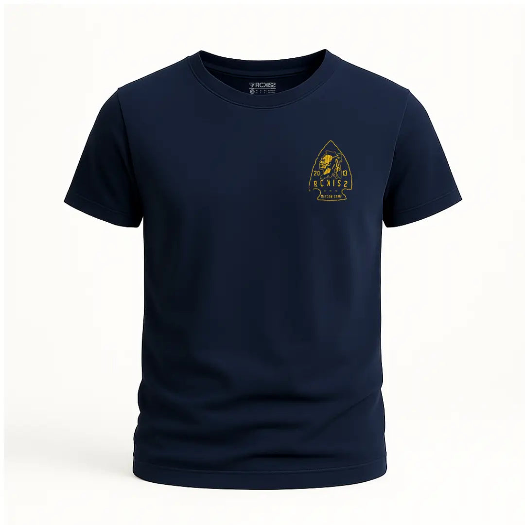 Playera azul marino con diseño trasero en forma de punta de flecha, figura de guerrero nativo y texto “Metcon Camp”, “2013” y “Tetakawi Ranch” en color amarillo. Estética rústica y tribal.
