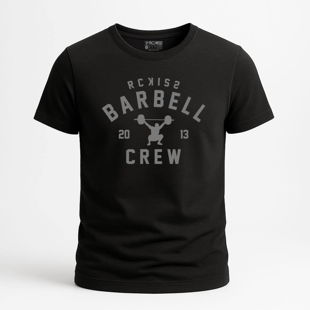 Playera color negro con diseño frontal en gris que incluye la frase “RCKISS BARBELL CREW 2013” y una figura levantando barra. Estilo deportivo, ideal para el entrenamiento.