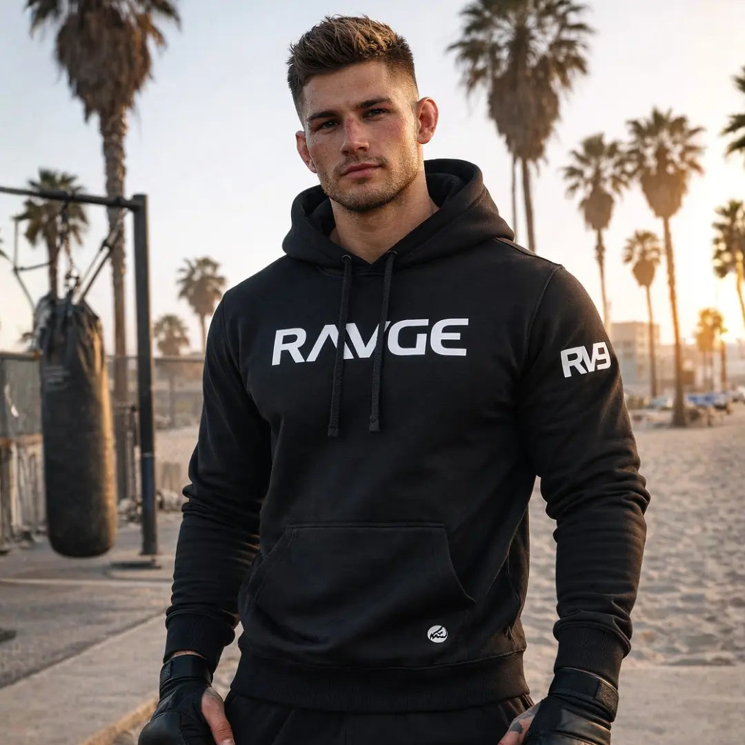 Modelo hombre con sudadera RAVGE Clasic negra Rckiss, look urbano fitness streetwear artes marciales